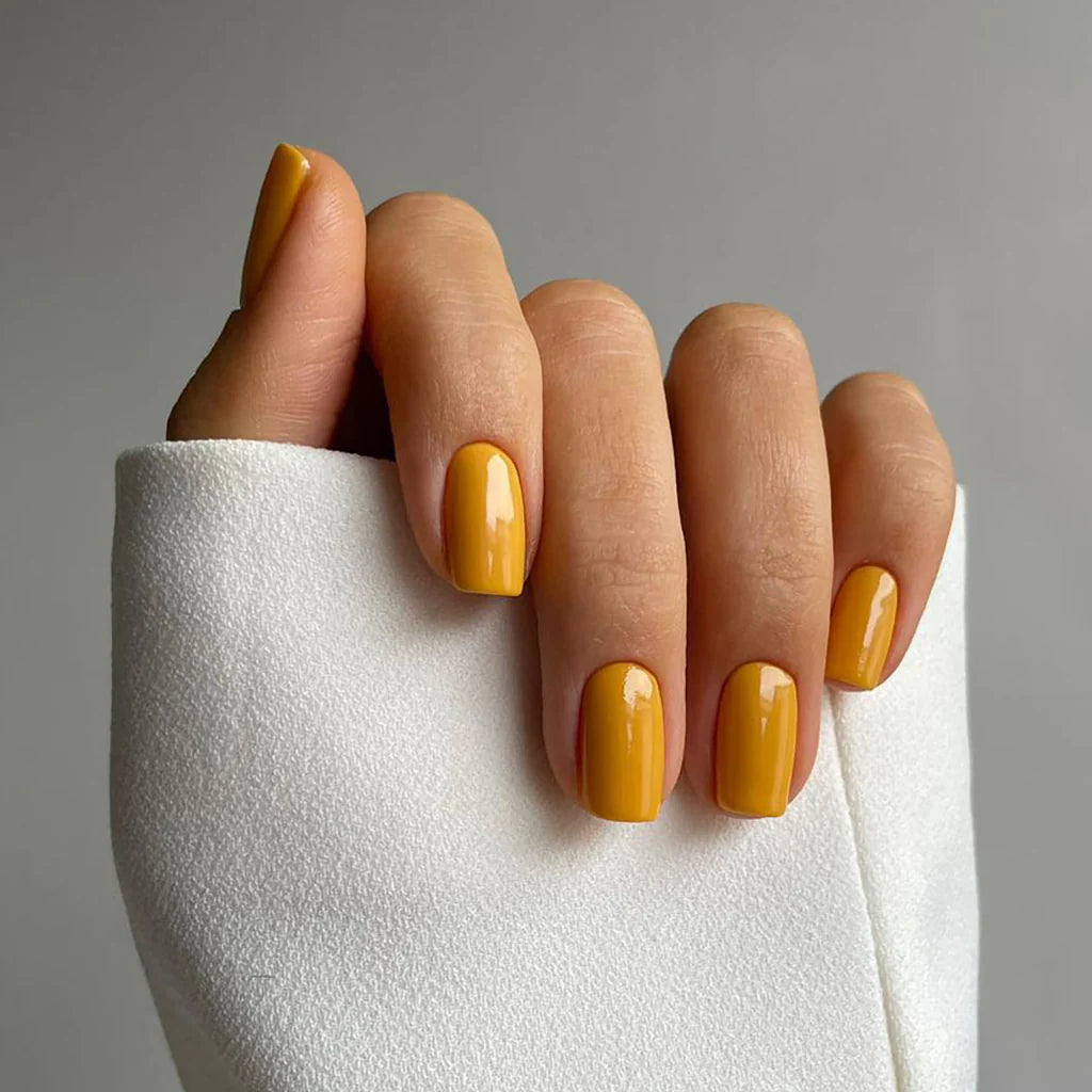 Fingers painted with Gemini Golden Hour on light skin – breathable, golden yellow polish for a fresh, everyday style