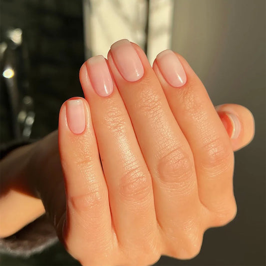 Hand with light skin tone wearing Bio Sculpture Transparent Beauty – sheer, vegan nude polish for a subtle, natural manicure