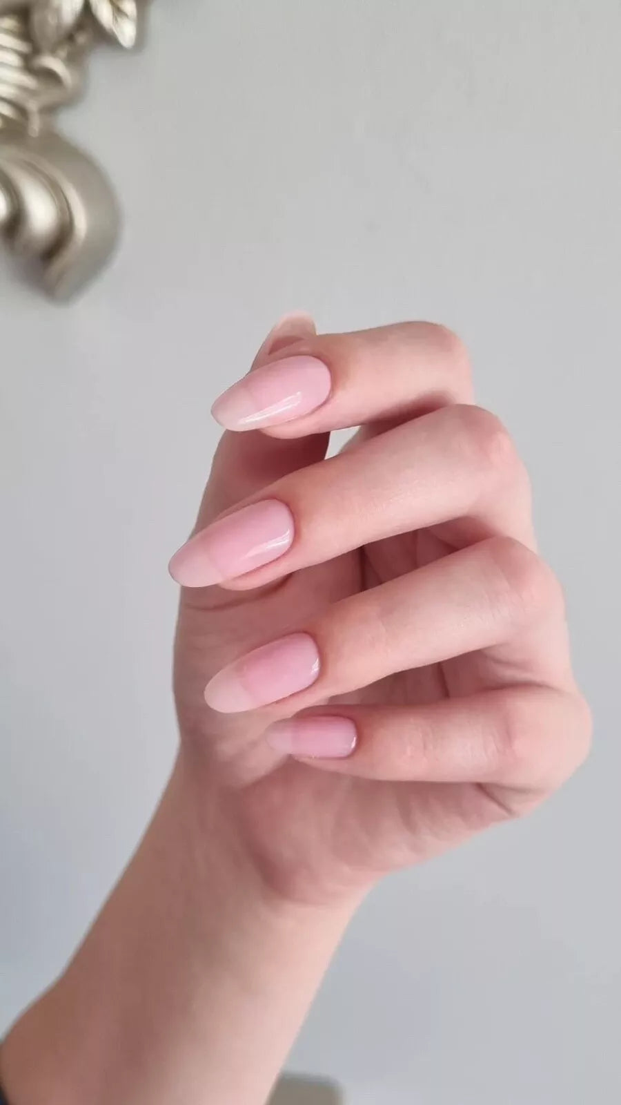 Hand with light skin tone wearing Bio Sculpture Sheer Admiration – sheer, vegan pink polish for a soft, natural manicure