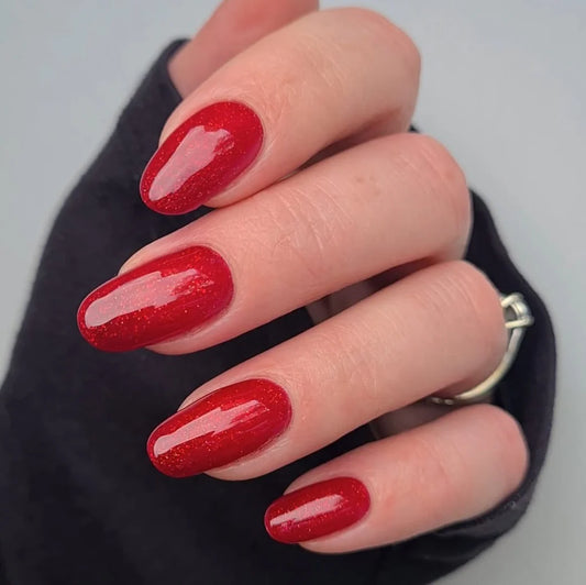 Close-up of Bio Sculpture Gemini Nail Polish No. 63 Moulin Rouge polish on light skin – non-toxic, classic red shade for a striking, elegant nail look