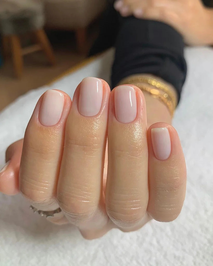 Fingers painted with Bio Sculpture Gemini Nail Polish No. 66, French Blanc on light skin – breathable, opaque white polish for a polished, versatile style