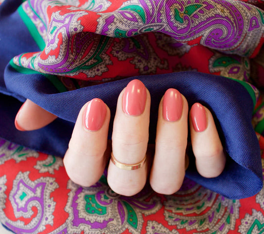 Hand wearing Bio Sculpture Gemini Nail Polish No. 6 Sugar Kiss – vegan, cool rose-pink polish for a chic, modern nail look