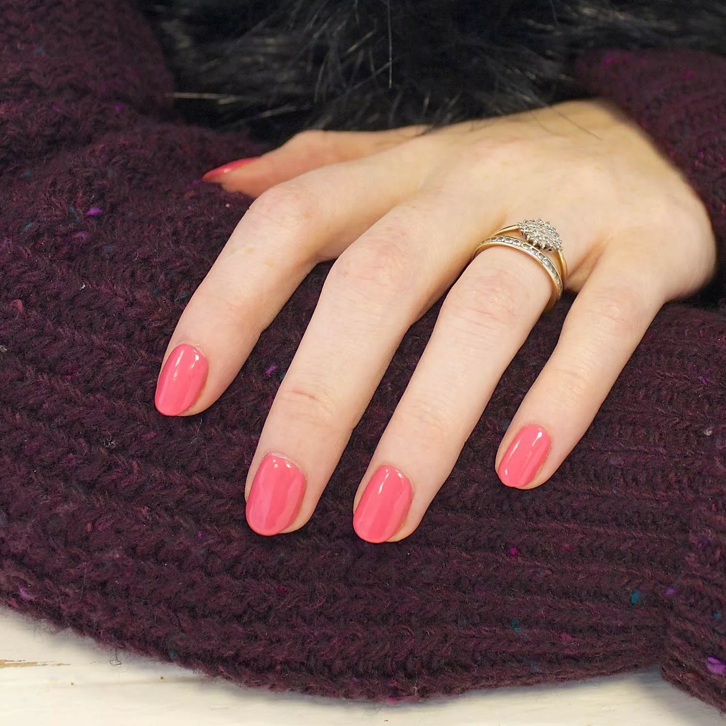 Hand with light skin tone wearing Bio Sculpture Gemini Nail Polish No. 75 Fruity Tooty – vegan, bright coral pink polish for a lively, chic nail look