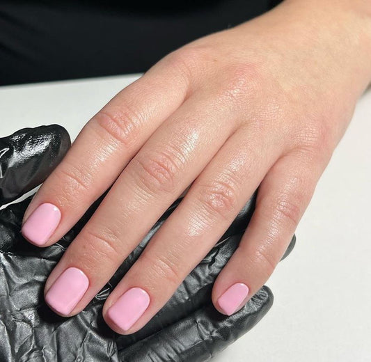 Hand wearing Bio Sculpture Gemini Nail Polish No. 78 Baby Doll – vegan, soft milky pink polish for a chic, understated nail look