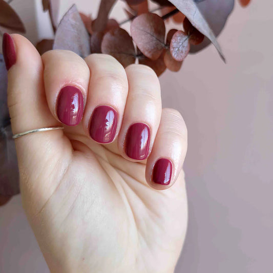 Close-up of Bio Sculpture Gemini Nail Polish No. 85 Mulberry polish on light skin – non-toxic, rich mulberry shade for a refined, modern nail look