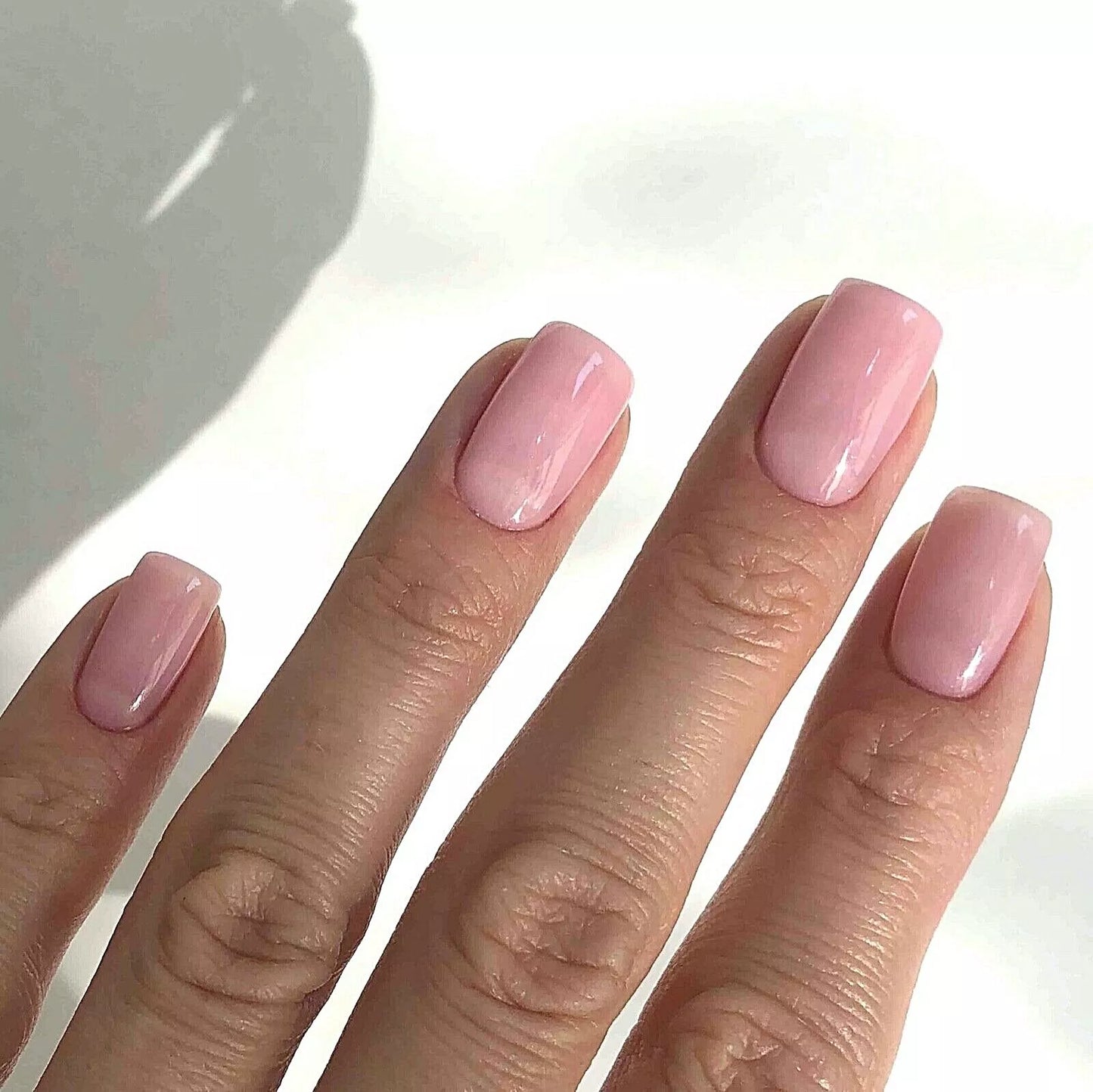 Fingers painted with Bio Sculpture Gemini Nail Polish No. 87 Strawberry French on light skin – breathable, creamy strawberry pink polish for a polished, romantic style