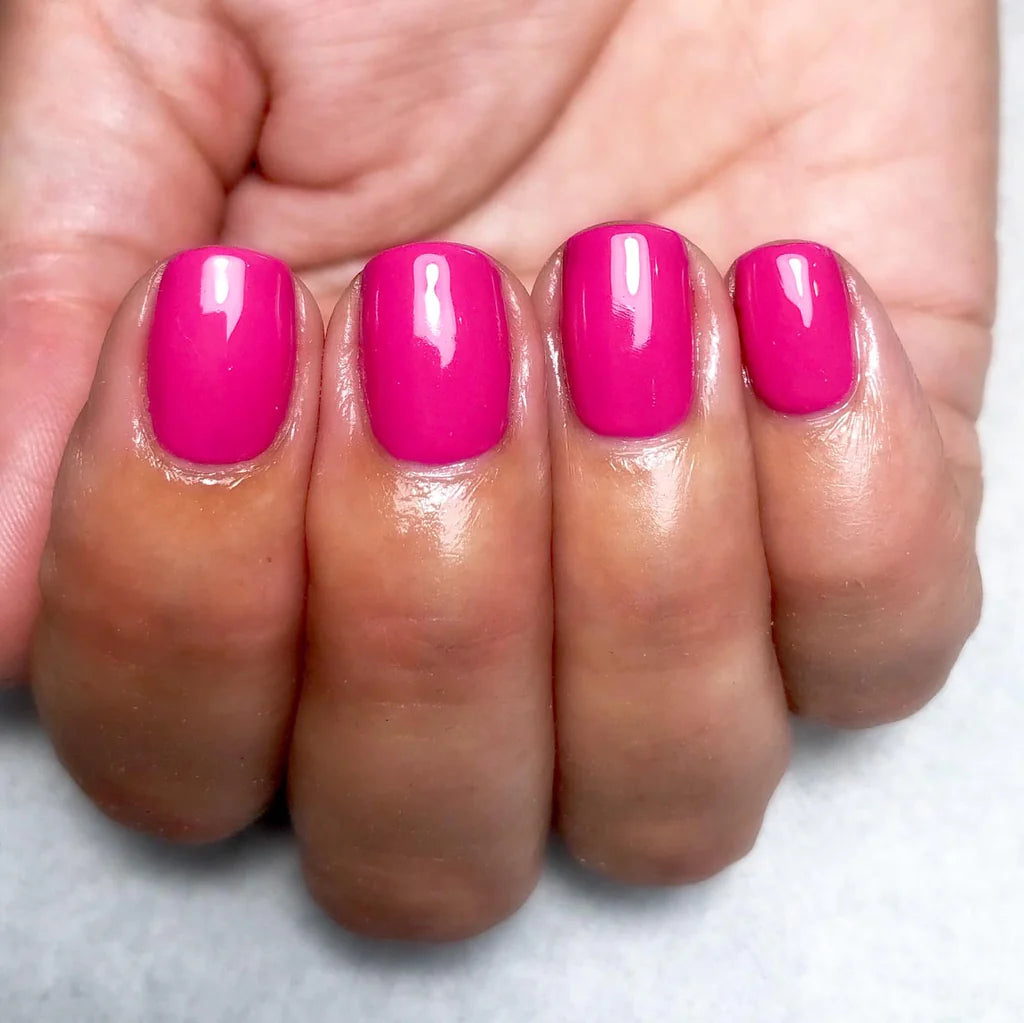 Hand wearing Bio Sculpture Gemini Nail Polish No. 89 Bright Summer Pink – bold, vegan vibrant summer pink polish for inclusive, radiant manicures