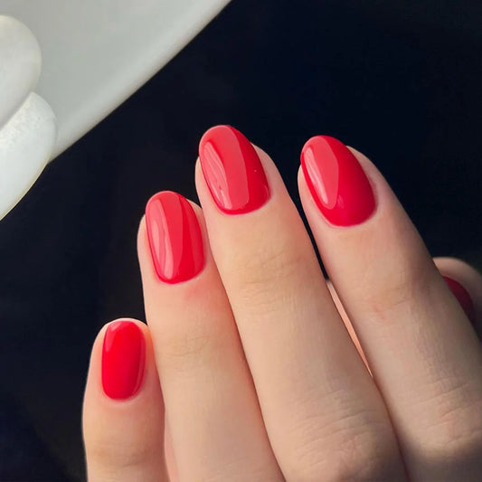 Hand wearing Bio Sculpture Gemini Nail Polish No. 94 Royal Red – vegan, rich bright red polish for a striking, elegant nail look
