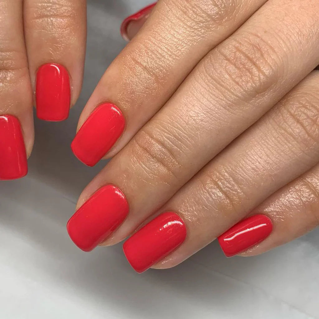 Hand wearing Bio Sculpture Gemini Nail Polish No. 96 Summer Holiday – vegan, bright pink coral polish for a vibrant, cheerful nail look