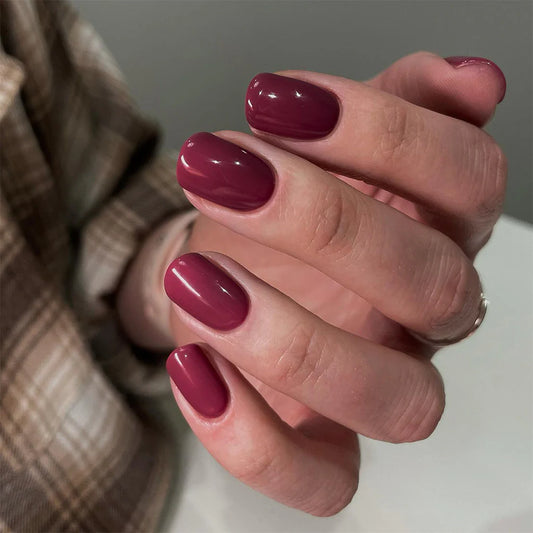 Close-up of Bio Sculpture Gemini Nail Polish No. 99 CCherry Liqueur polish on light skin – non-toxic, rich cherry red shade for a refined, modern nail look