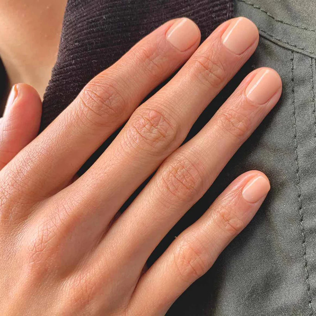 Hand with light skin tone wearing Bio Sculpture Gemini Nail Polish No. 2095 Nude Beige – soft, vegan nude beige polish for a chic, natural manicure