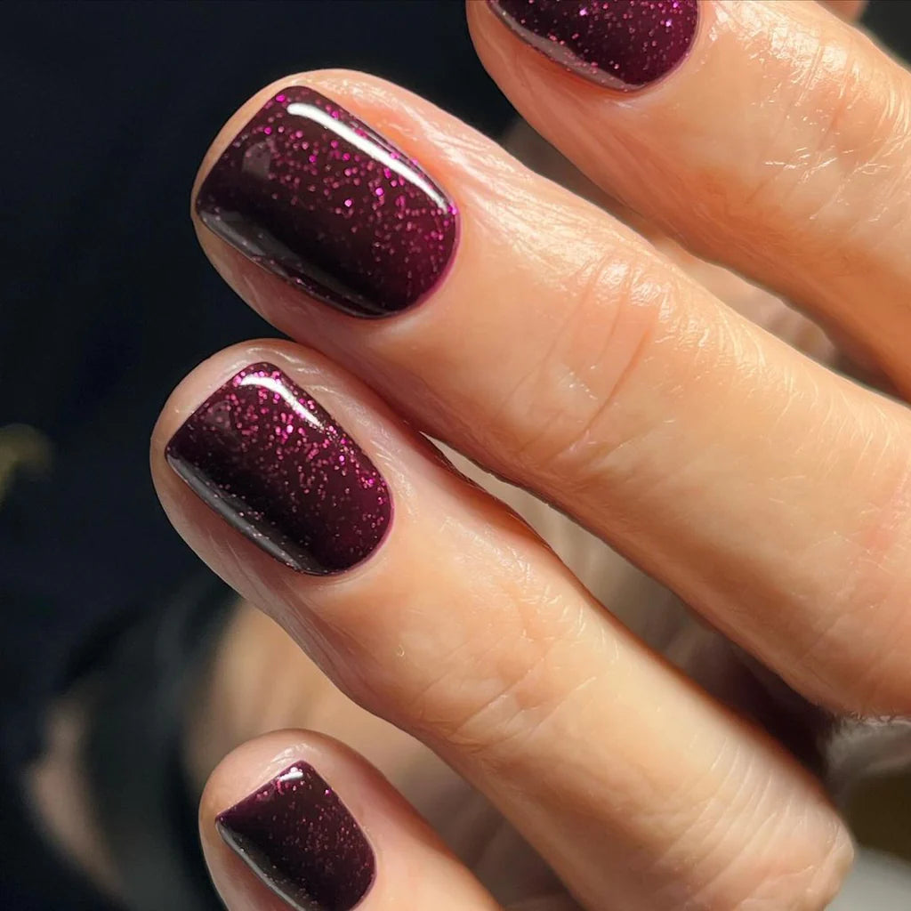 Fingers painted with Bio Sculpture Gemini Nail Polish No. 221 Party Popper on light skin – breathable, bright confetti pink polish for a polished, party-ready style