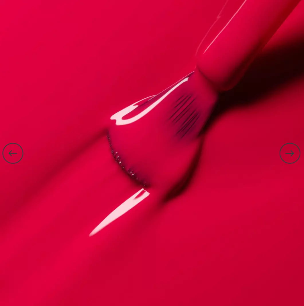 Polish brush dipped in Manucurist Peonie nail polish – creamy, vegan peony pink formula for smooth application