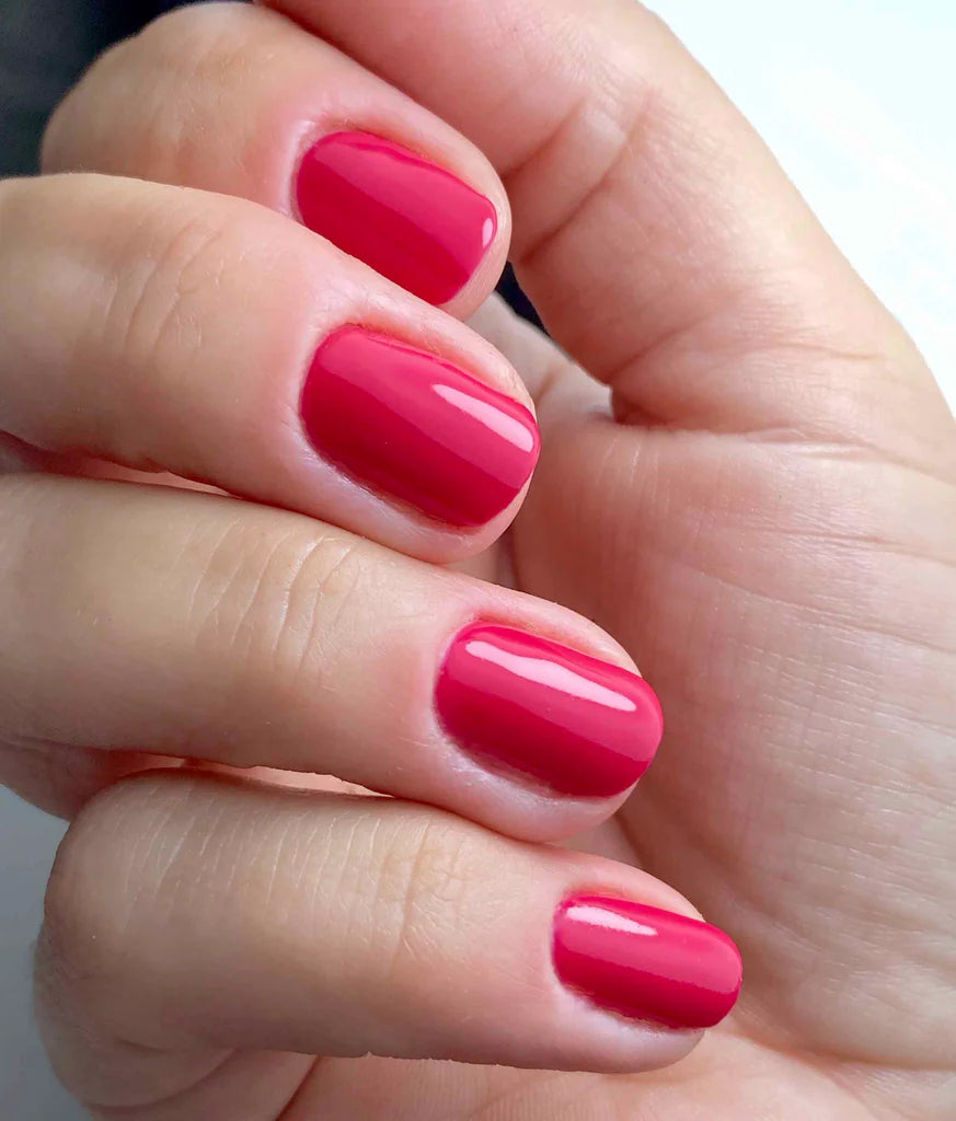 Hand wearing Bio Sculpture Gemini Nail Polish No. 18 Paradise Pink – vegan, deep crimson polish for a chic, sophisticated nail look