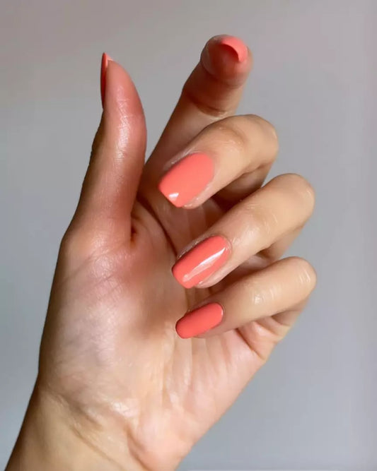 Hand with light skin tone wearing Nailberry Peony Blush – soft, non-toxic peony pink polish for a chic, natural nail look