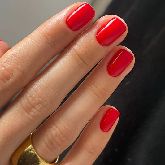 Hand wearing Bio Sculpture Gemini Nail Polish No. 19 Pillar Box Red – vegan, vibrant pillar box red polish for a striking, timeless nail look