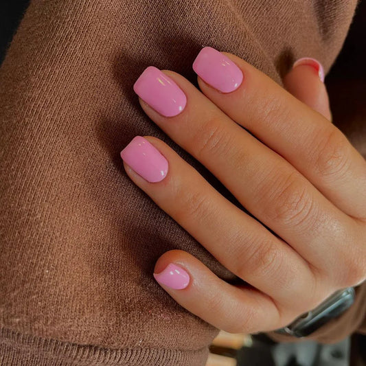 Hand wearing Bio Sculpture Gemini Nail Polish No. 65 Pink Iceberg – vegan, pastel baby pink polish for a gentle, elegant nail look