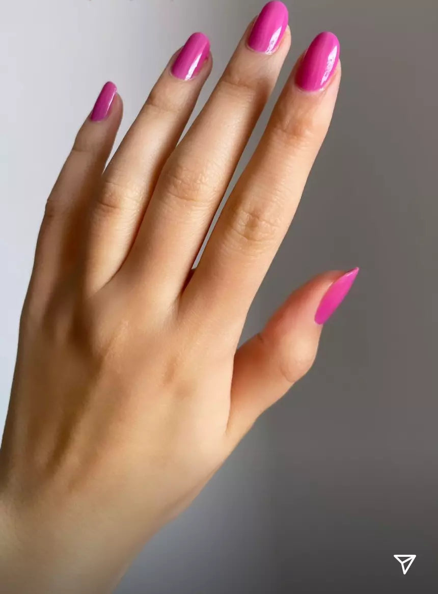 Hand with light skin tone wearing Nailberry Pomegranate Juice – rich, vegan pomegranate red polish for a bold, elegant manicure
