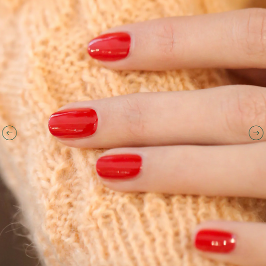 Hand with light skin tone wearing Manucurist Poppy Red – bright, vegan red polish for a striking, classic manicure