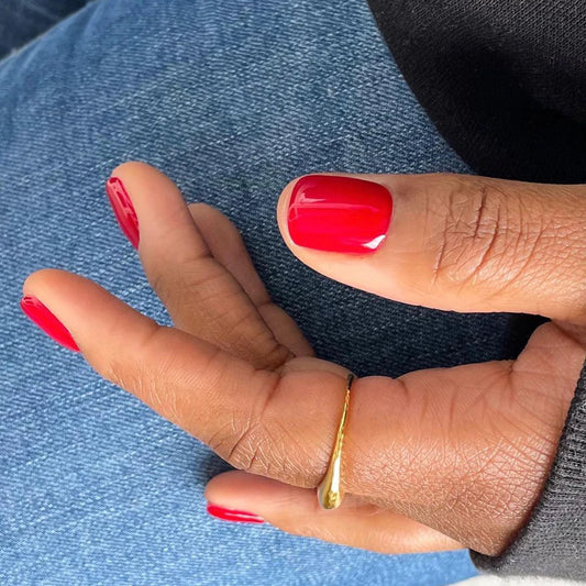 Hand wearing Bio Sculpture Gemini Nail Polish No. 74 Real Red – vegan, deep true red polish for a striking, elegant nail look