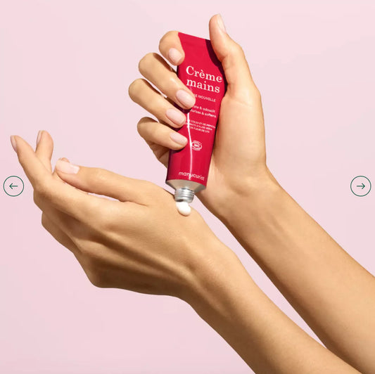 Hand with light skin tone applying Manucurist Rose Nouvelle Hand Cream – gentle, vegan rose formula for smooth, moisturised hands
