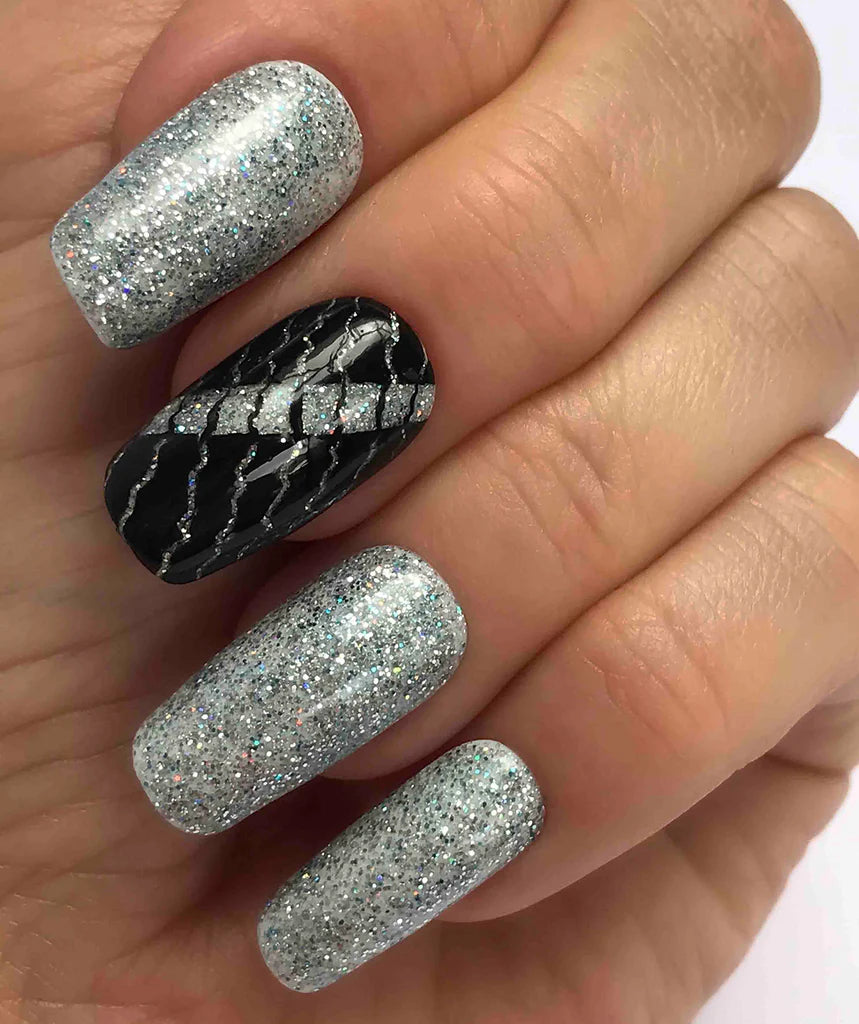 Hand wearing Bio Sculpture Gemini Nail Polish No. 264 Sapphire Song – bold, vegan silver and blue sapphire glitter polish for inclusive, glamorous manicures