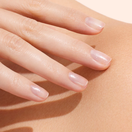 Hand with light skin tone wearing Manucurist Active Shine – clear, vegan glossy base coat for a natural, luminous manicure