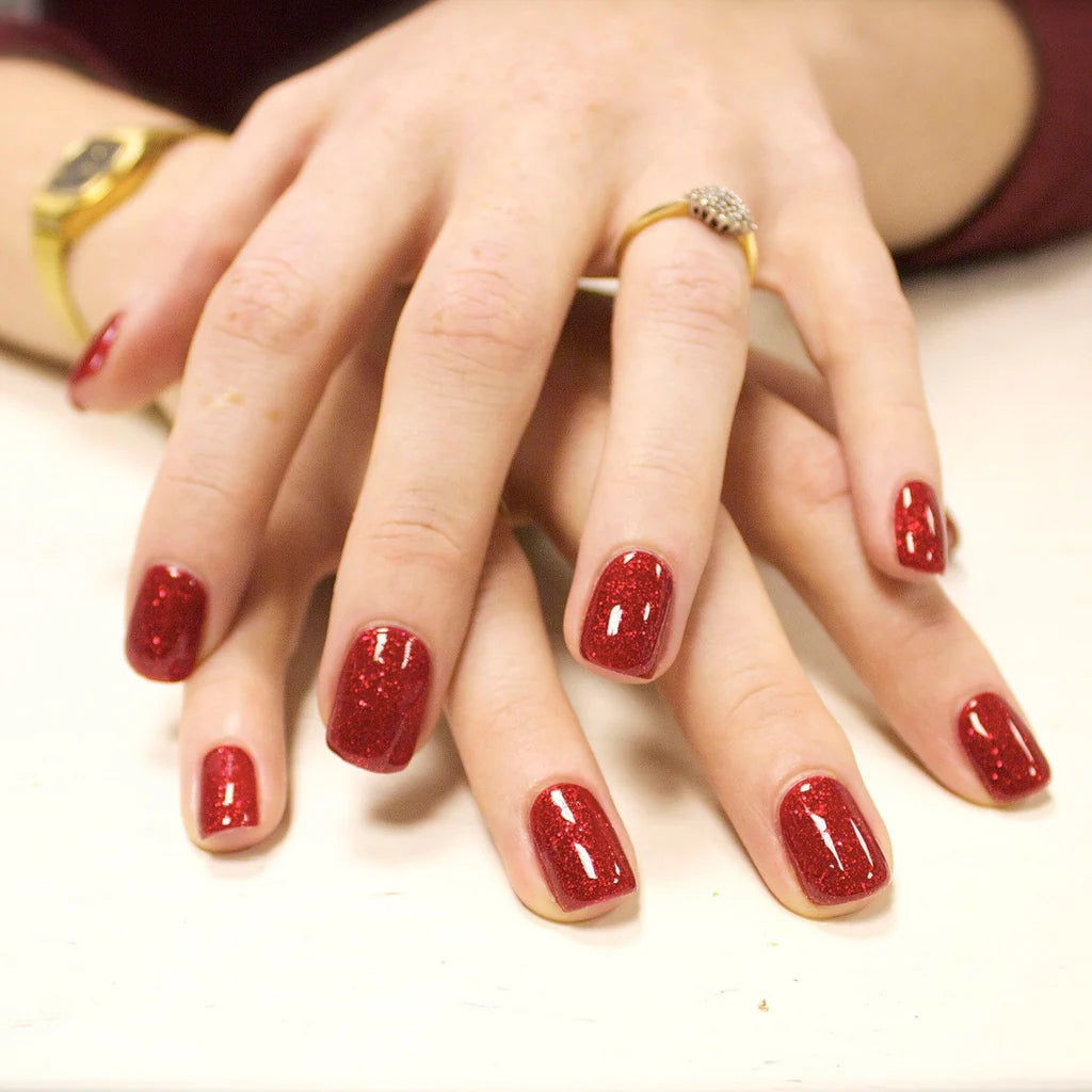 Close-up of Bio Sculpture Gemini Nail Polish No. 167 Seductive Lights polish on light skin – non-toxic, sparkling berry shade with fine glitter for a radiant, party-ready nail look