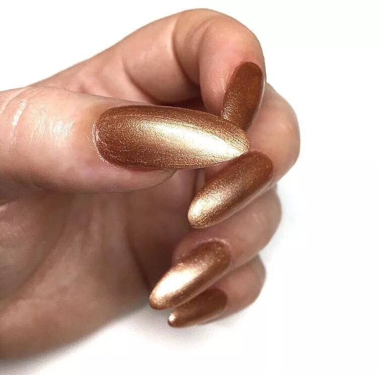 Hand wearing Bio Sculpture Gemini Nail Polish No. 169 The Rebel – bold, vegan pearlescent rose gold polish for inclusive, glowing manicures