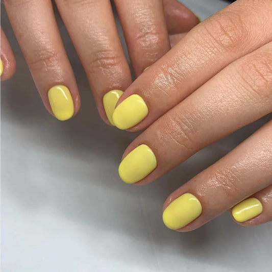 Hand wearing Bio Sculpture Gemini Nail Polish No. 248 Tropical Sunray – vegan, pastel yellow polish for a fresh, sunny nail look
