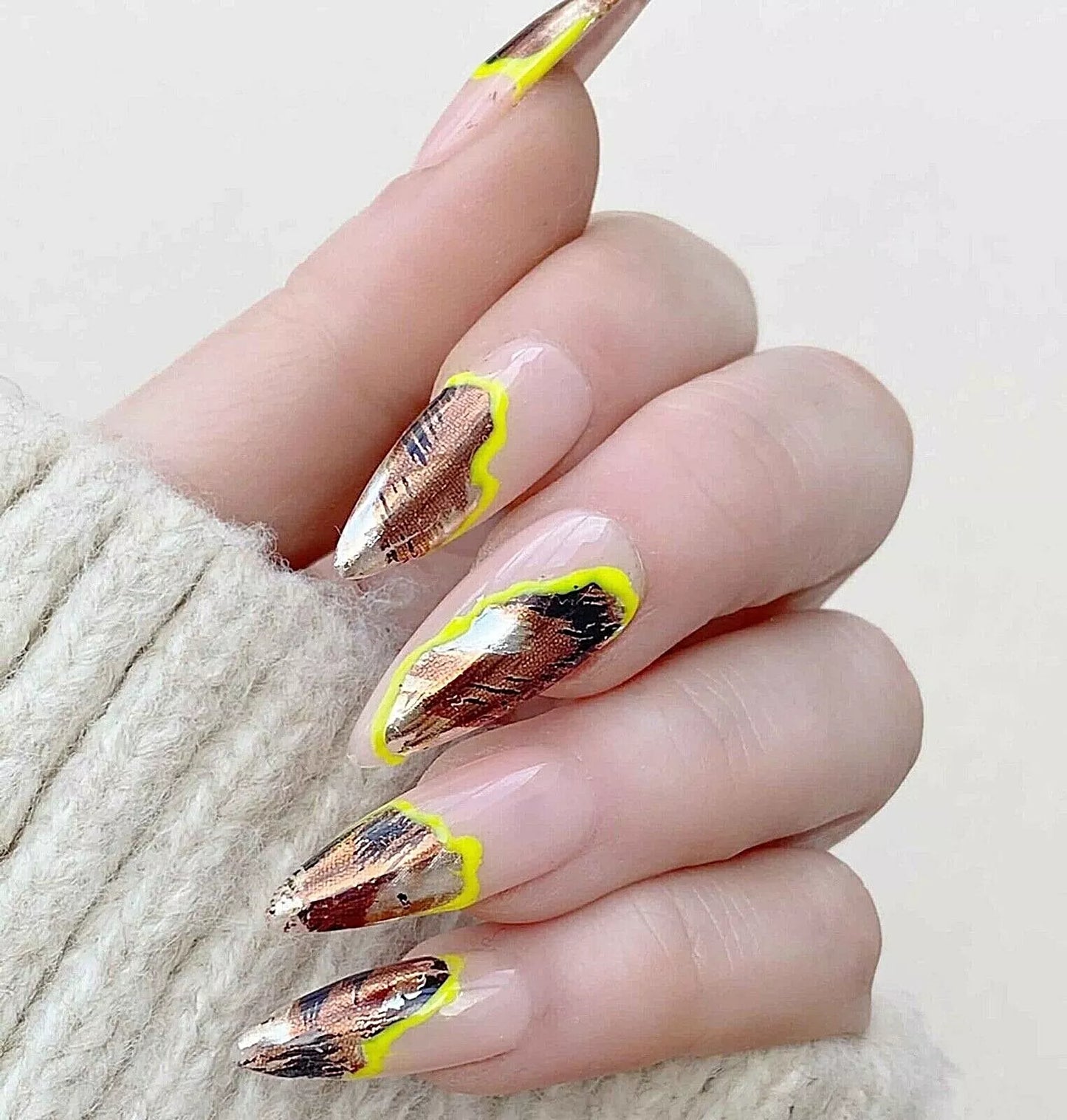 Close-up of the Bio Sculpture, Essence, wild animal print foil nail art on light skin – bold, multi-patterned foil for a unique, stylish nail look
