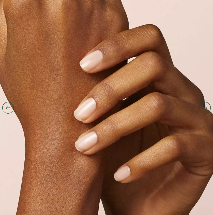 Close-up of manicured hands with nude nail polish showcasing healthy, vibrant nails and smooth skin tone.