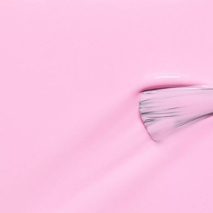 Polish brush dipped in Manucurist Candy nail polish – creamy, non-toxic pastel pink formula for smooth, even application