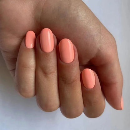 Hand with dark skin tone wearing Bio Sculpture Gemini Nail Polish No. 249  Coral Cluster – bold, vegan bright coral polish for inclusive, radiant manicures