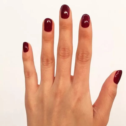 Close-up of Dakota polish on light skin – non-toxic, classic deep red shade for timeless nail looks