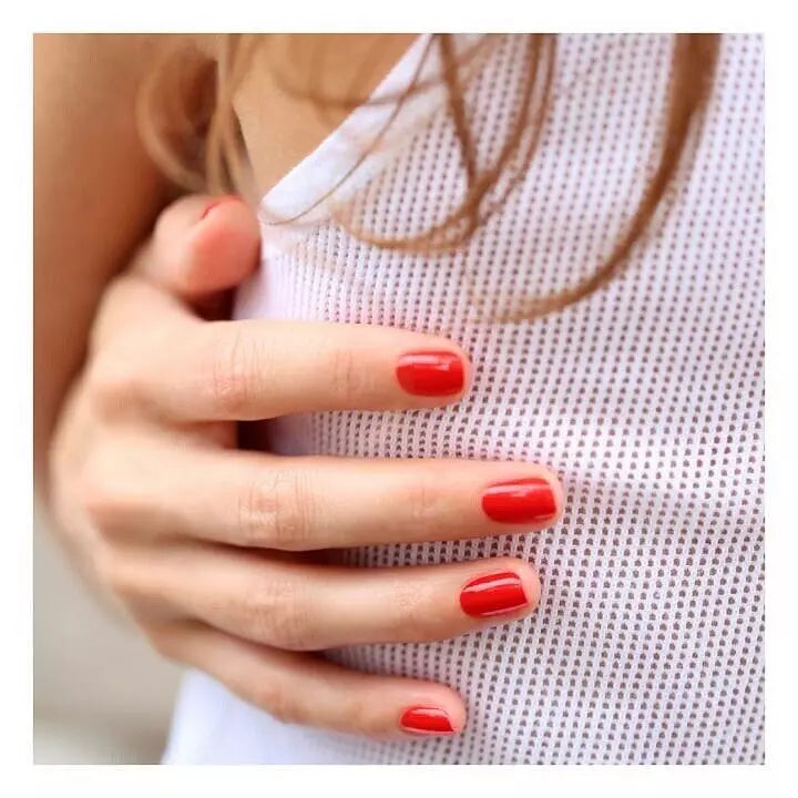 Hand with Poppy Red Manucurist Green Flash gel polish – vibrant, vegan red gel alternative for a glossy, salon-quality manicure