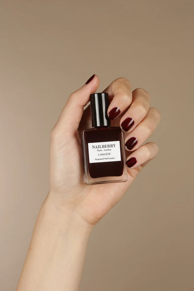 Hand with light skin tone wearing Nailberry Noirberry – deep, vegan berry polish for elegant, sophisticated manicures