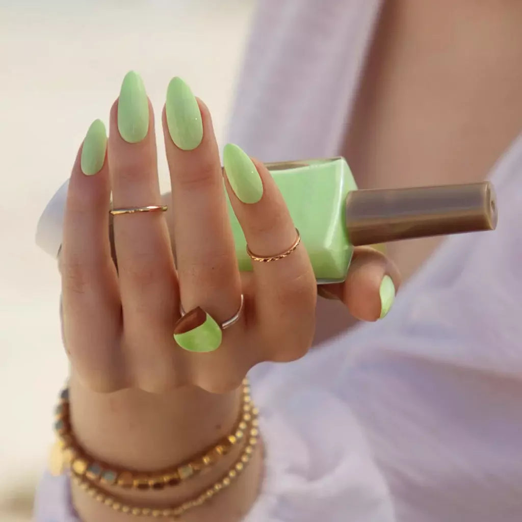Hand holding Bio Sculpture Gemini Green Apple Smoothie nail polish – vegan, pastel green polish bottle for stylish, summery nails