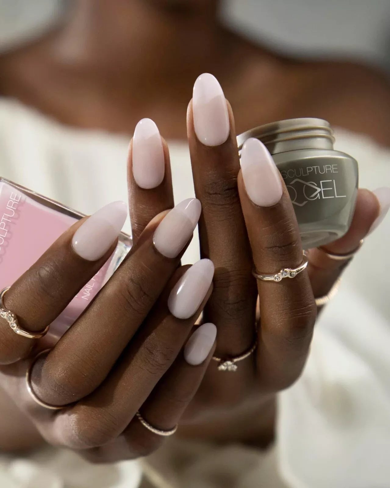 Hand with dark skin tone wearing Bio Sculpture Transparent Beauty – sheer, vegan nude polish for an inclusive, understated manicure