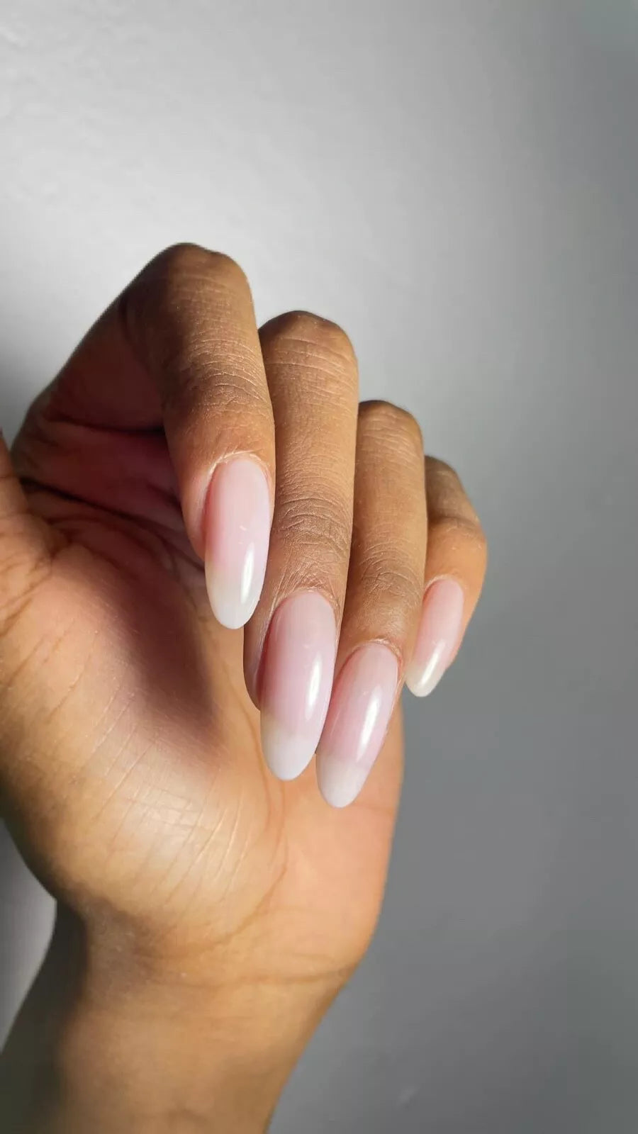 Fingers painted with Gemini Transparent Beauty on light skin – breathable, sheer nude polish for a minimalist nail look