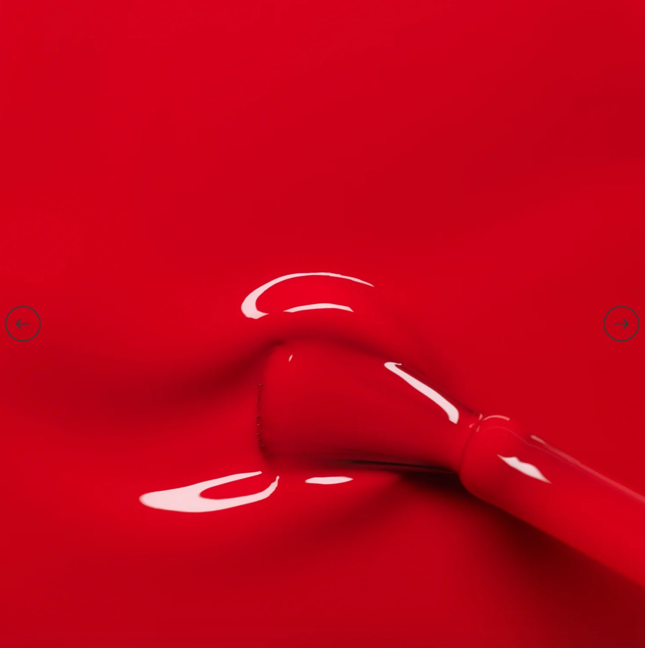 Polish brush dipped in Manucurist Poppy Red nail polish – creamy, non-toxic red formula for smooth, even application