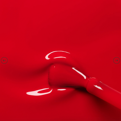 Polish brush dipped in Manucurist Poppy Red nail polish – creamy, non-toxic red formula for smooth, even application