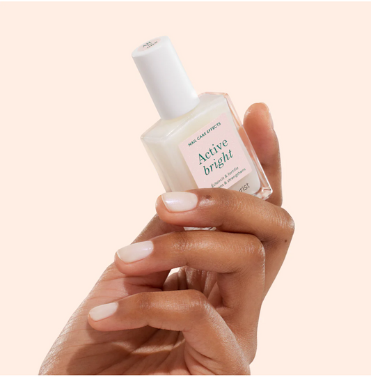 Hand holding Manucurist Paris Green Range Base Coat Active Bright – plant-based, non-toxic brightening base coat for nail care