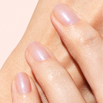 Hand with light skin tone wearing Manucurist Active Bright – clear, vegan brightening base coat for a natural, glowing manicure