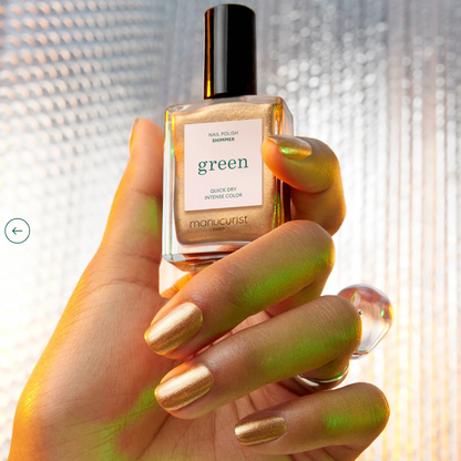 Hand holding Manucurist Paris Green Range Shimmer – luminous, plant-based nude shimmer nail polish bottl
